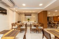 ブルスケにあるTri Hotel Executive Brusqueの木製のテーブルと椅子のあるダイニングルーム