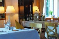 een restaurant met witte tafels en flessen wijn bij Hotel Schlossvilla Derenburg in Derenburg