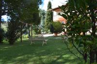 a park bench sitting in the grass near a house at Pousada Sino dos Ventos in Campos do Jordão