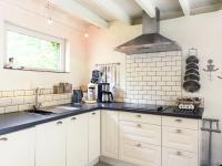 a kitchen with white cabinets and black counter tops at This accommodation is full of atmosphere and on a beautiful estate in Zedelgem