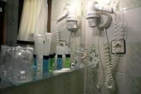 a bathroom mirror with several hair dryers on a wall at Casa Rural Priena in Covadonga