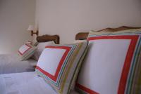 two beds with colorful pillows on them in a bedroom at Casa Rural Priena in Covadonga