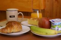 a table with a plate of food and a cup of orange juice at Casa Rural Priena in Covadonga