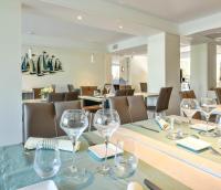 a dining room with wine glasses on a table at Les Vagues Hôtel Restaurant in Biscarrosse-Plage