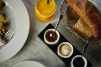 a table with a plate of bread and a glass of orange juice at The Melegran in Rovinj