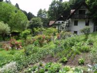 a garden in front of a house with flowers at Ferienhaus Himmelreichmühle in Rettenberg