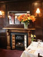 a fireplace with a vase of flowers on top of it at Rising Sun Hotel in Lynmouth