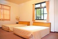 two beds in a room with a window at Kaohsiung Meinong Rabbit Paul Homestay B&amp;B in Meinong