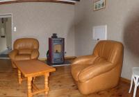 two leather chairs and a wood stove in a living room at Gîte rural Les Maires d&#39;Avaux in Saint-Bresson