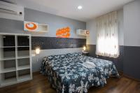 Un dormitorio con una cama con una colcha azul y blanca. en Hostal Gaudi Cuenca, en Cuenca