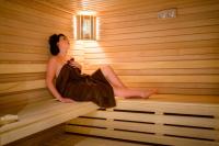 a woman is sitting in a sauna at Saint Georges Hotel &amp; Spa in Chalon-sur-Saône