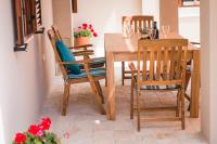 a dining room with a wooden table and chairs at Holiday Home Lukica in Privlaka