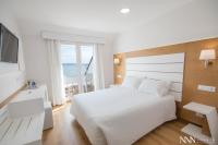 A bed or beds in a room at Hotel Spa Nanin Playa