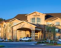 Un hotel con un coche aparcado delante. en ClubHouse Hotel and Suites, en Pierre