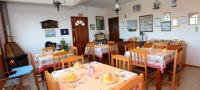 a restaurant with tables and chairs with dishes on them at Pousada Colina Da Neve in São Joaquim