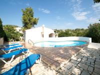 a swimming pool with blue chairs next to a house at Villa Halibut by Interhome in Fanadix