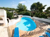 a blue swimming pool on a patio with chairs around it at Villa Halibut by Interhome in Fanadix