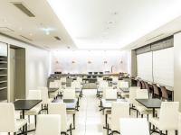 HOTEL MYSTAYS Shimizu في شيزوكا: غرفة طعام كبيرة مع طاولات وكراسي بيضاء