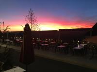 a patio with tables and a umbrella and a sunset at Hotel du Rempart in Sancerre