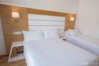 A bed or beds in a room at Hotel Spa Nanin Playa