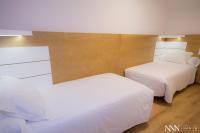 A bed or beds in a room at Hotel Spa Nanin Playa
