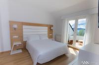 A bed or beds in a room at Hotel Spa Nanin Playa