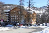 a large building with cars parked in the snow at L&#39;Ecrin des Neiges in Vars