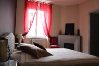 Schlafzimmer mit einem Bett und einem Fenster mit roten Vorhängen in der Unterkunft Le Patio Gironnais in Saint-Girons