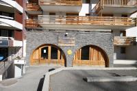 a building with two entrances with wooden doors at L&#39;Ecrin des Neiges in Vars