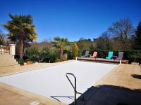 a swimming pool in a backyard with two lawn chairs and aitating at Le Mas des Geais in Atur