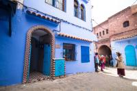 a group of people standing outside a blue building at Résidence chaounia d&#39;hote in Chefchaouene