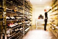 a man looking at a wine rack in a wine store at Hotel de l'Opera Hanoi - MGallery in Hanoi