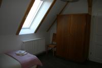 a bedroom with a bed and a cabinet and a window at Apartment Jakobsweg GbR in Pettstädt