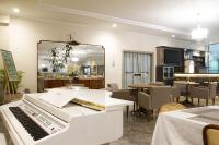ein weißes Klavier in einem Raum mit einem Restaurant in der Unterkunft Hotel Dan Inn Franca & Convenções By Nacional Inn in Franca