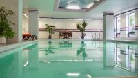 una piscina en un edificio con una mesa en Cartier Place Suite Hotel, en Ottawa