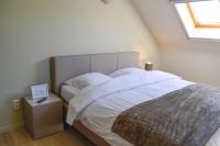 a bedroom with a bed with white sheets and a window at B&amp;B Onderweg in Horebeke