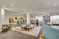 モルパにあるMercure Maurepas Saint Quentinのテーブルと椅子とバーのあるレストラン