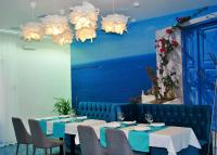 a dining room with tables and chairs and blue walls at Biruza Club in Svyatopetrivske