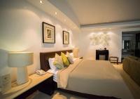 Un dormitorio con una cama y una mesa con una lámpara. en Hotel Grand Marlon, en Chetumal