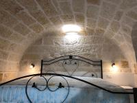 una cama en una habitación con techo de piedra en casa principe di napoli, en Polignano a Mare