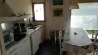 - une cuisine avec une table et un comptoir dans l&#39;établissement La maison des bois flottés, à Guérande