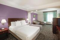 Cama grande en habitación de hotel con paredes púrpuras en La Quinta by Wyndham Mansfield TX, en Mansfield