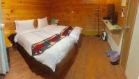 a bedroom with a large bed in a wooden room at New Life Hot Spring Resort in Yuli