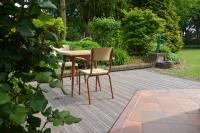 two chairs and a table in a garden at La Coulonnière in Wismes