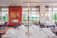 Best Western Premier Castanea Resort Hotel في لونبورغ: غرفة طعام بها طاولات وكراسي بيضاء