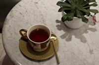 a cup of tea on a plate on a table with a plant at The Melegran in Rovinj