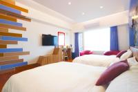 a hotel room with two beds and a tv at 36 Lighthouse in Hualien City