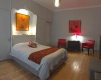 a bedroom with a bed and two red chairs at LES CHAMBRES D&#39;HOTES DU PALAIS in Douai