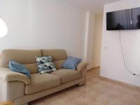 a living room with a couch and a flat screen tv at El apartamento de Marina en Chilches playa in Xilxes