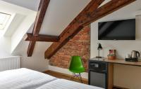 a bedroom with a bed and a green chair at Hotel Garden Court in Prague